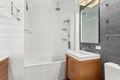 bathroom featuring toilet, vanity, and a combined bath / shower with rainfall shower