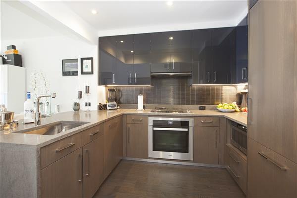 kitchen with a sink, light countertops, appliances with stainless steel finishes, decorative backsplash, and dark wood-style floors