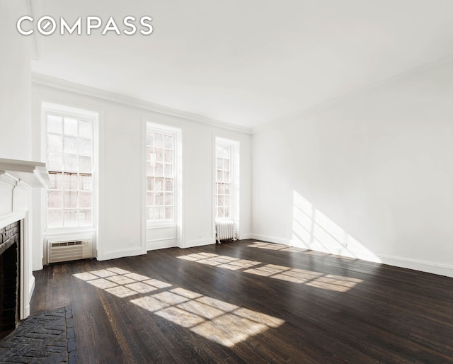 unfurnished living room featuring dark wood finished floors, a fireplace, radiator heating unit, and ornamental molding