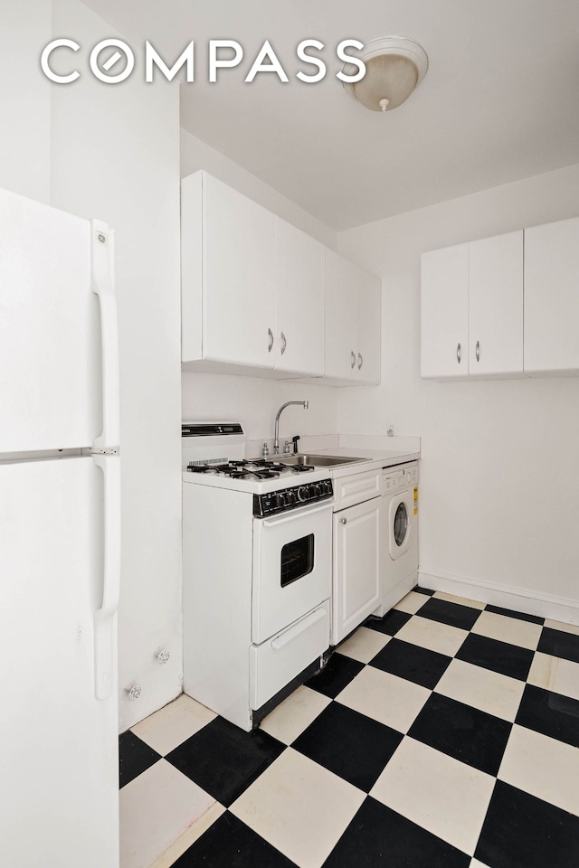 kitchen featuring white appliances, light floors, washer / clothes dryer, a sink, and white cabinetry