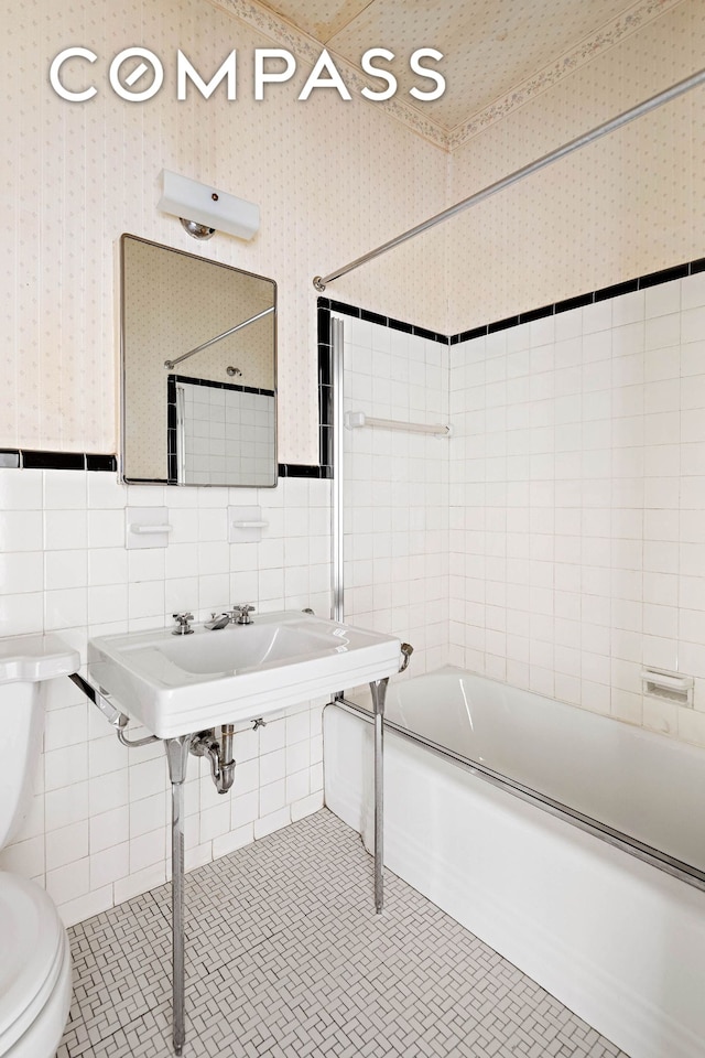 full bathroom featuring tile patterned flooring, tile walls, toilet, and shower / bathing tub combination