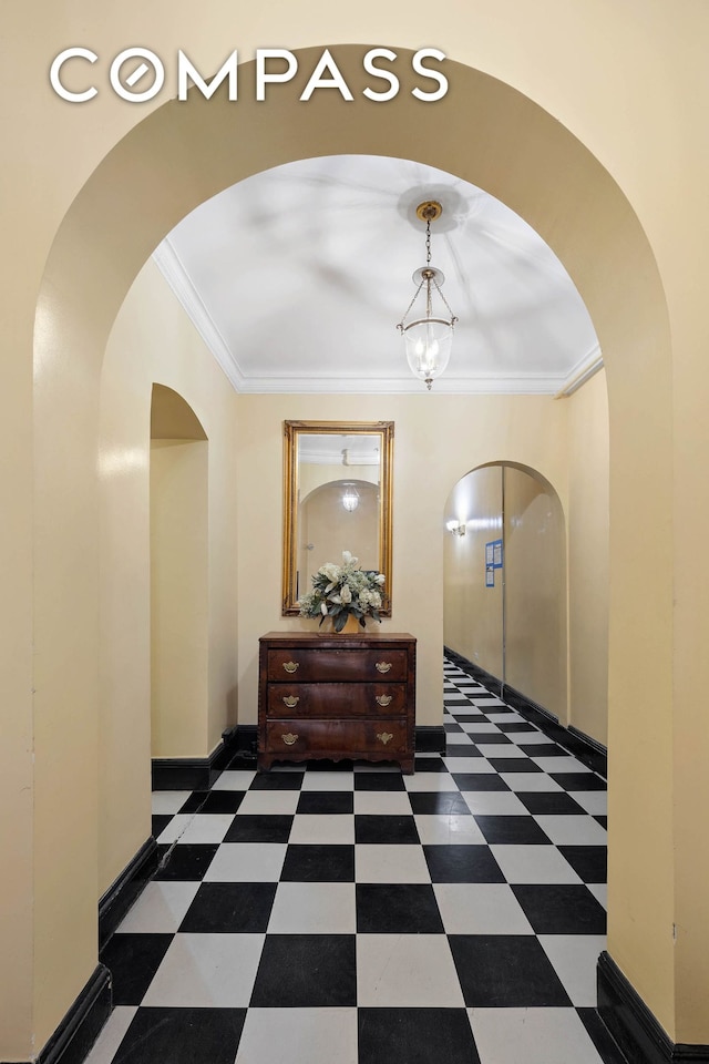 hallway with crown molding, baseboards, tile patterned floors, and a chandelier