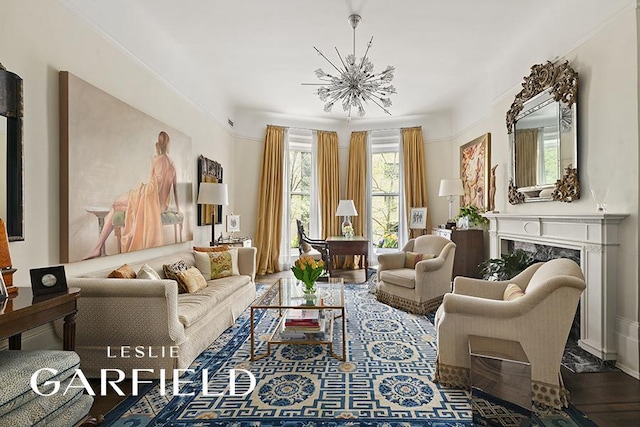 sitting room with a fireplace, a chandelier, and wood finished floors