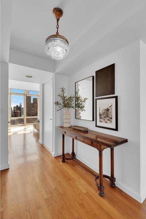 corridor featuring a notable chandelier and light hardwood / wood-style flooring