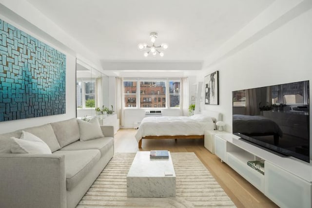 bedroom featuring an inviting chandelier and light hardwood / wood-style floors