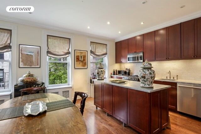 kitchen featuring sink, hardwood / wood-style floors, stainless steel appliances, and a kitchen island