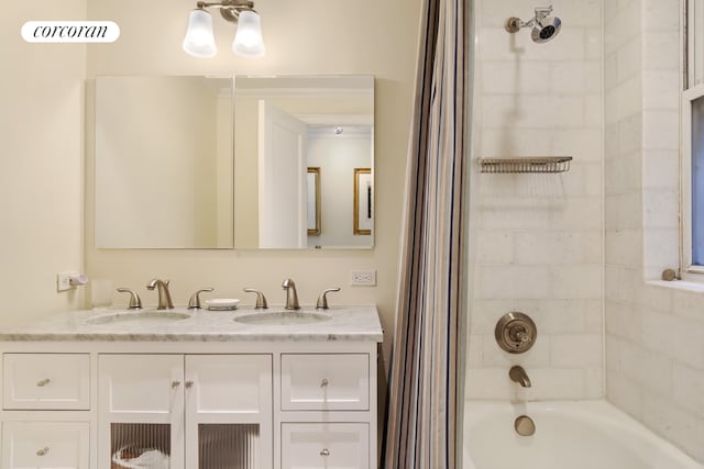 bathroom with tiled shower / bath combo and vanity