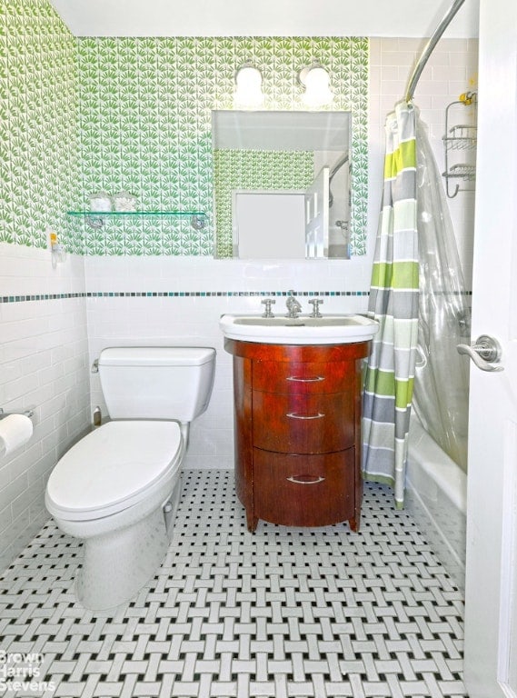 full bathroom with shower / bath combination with curtain, vanity, toilet, and tile walls