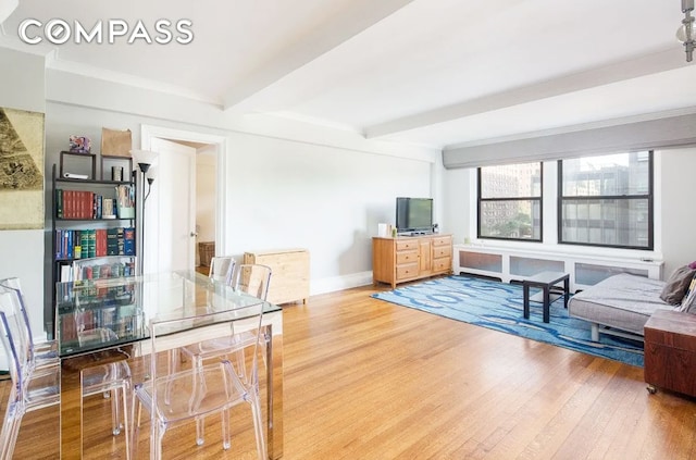 interior space with wood finished floors, beam ceiling, and baseboards