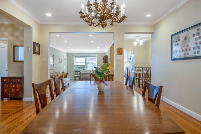 dining room featuring ornamental molding, ceiling fan with notable chandelier, and wood-type flooring