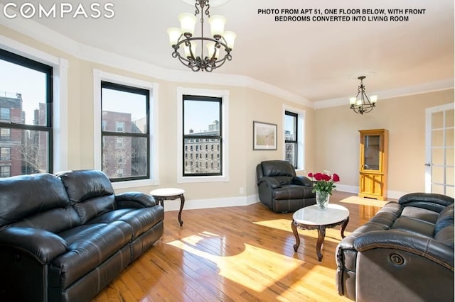 living room featuring crown molding, light hardwood / wood-style floors, and a notable chandelier