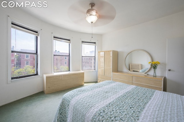 bedroom featuring ceiling fan, multiple windows, and carpet flooring