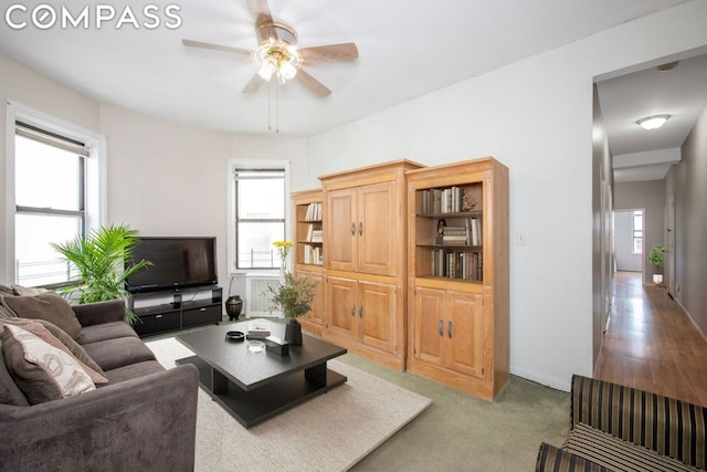 living room featuring ceiling fan, plenty of natural light, and carpet flooring