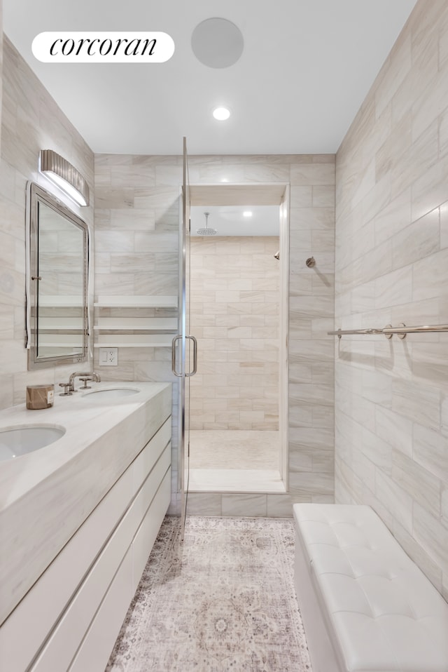 1474 3rd Ave Unit 16Ns, New York City, NY 10028 - bathroom with a shower stall, tile walls, double vanity, tile patterned flooring, and recessed lighting