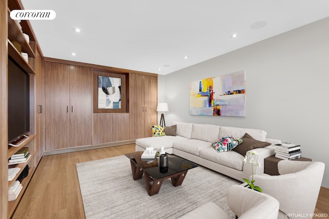 living room with wooden walls and light hardwood / wood-style flooring