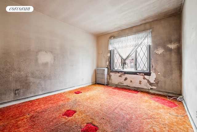 carpeted spare room with visible vents and radiator