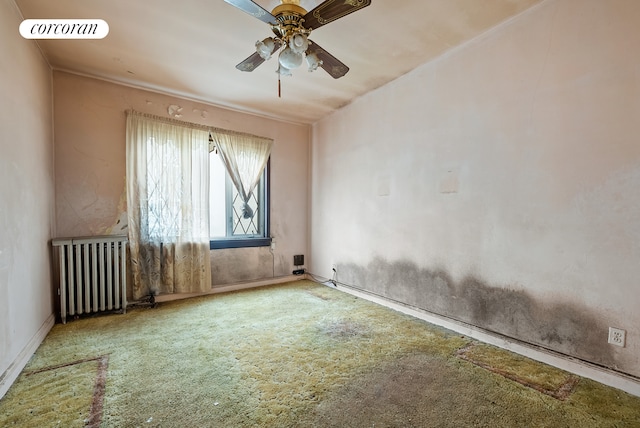 empty room with visible vents, radiator, carpet, and a ceiling fan