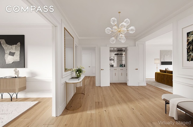 hall with ornamental molding, hardwood / wood-style floors, and an inviting chandelier