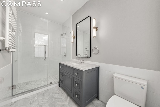 bathroom featuring an enclosed shower, radiator heating unit, vanity, tile walls, and toilet