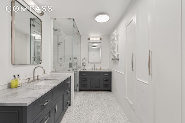 110 W 81st St, New York City, NY 10024 - bathroom featuring radiator, a shower stall, two vanities, and tile patterned floors