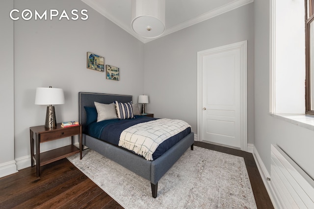 bedroom featuring crown molding, dark wood finished floors, and baseboards