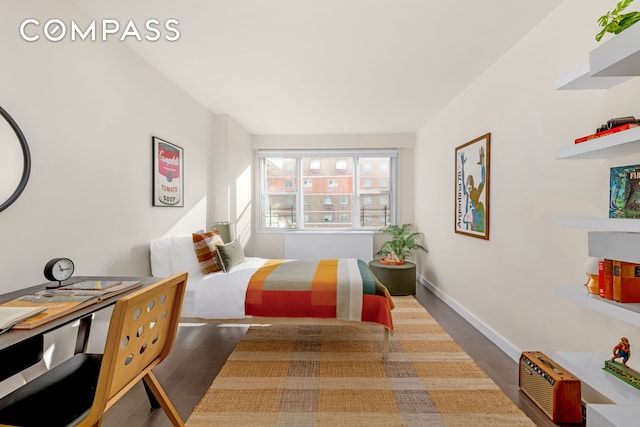 bedroom with baseboards and wood finished floors