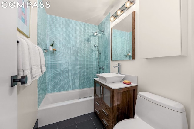 full bathroom featuring toilet, vanity, tiled shower / bath combo, and tile patterned flooring