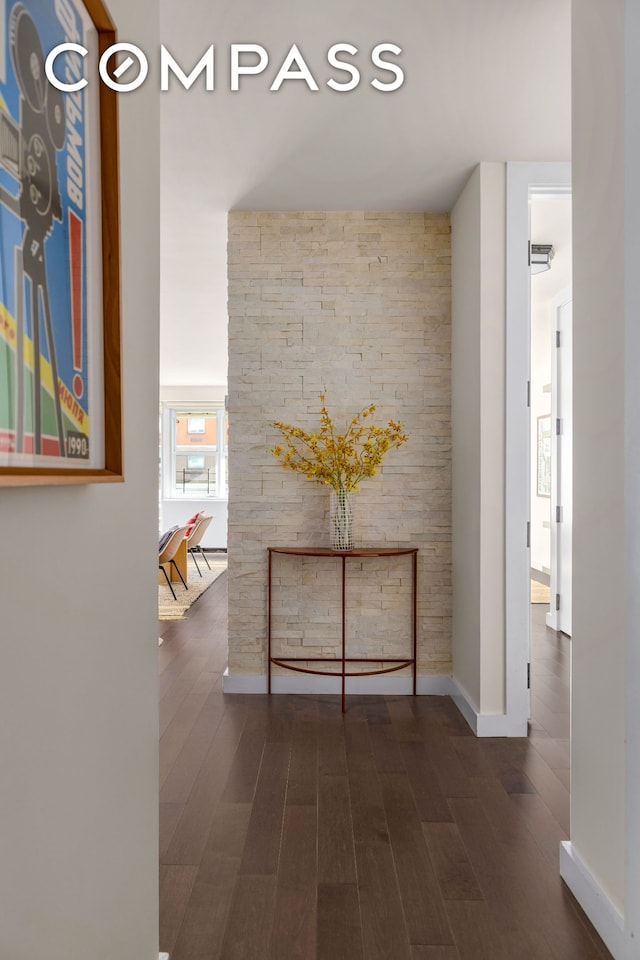 hall with dark wood-type flooring and baseboards