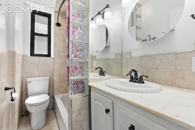 bathroom with tile patterned floors, toilet, tile walls, and vanity