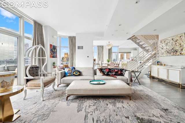 living room with expansive windows, wood-type flooring, and a wealth of natural light