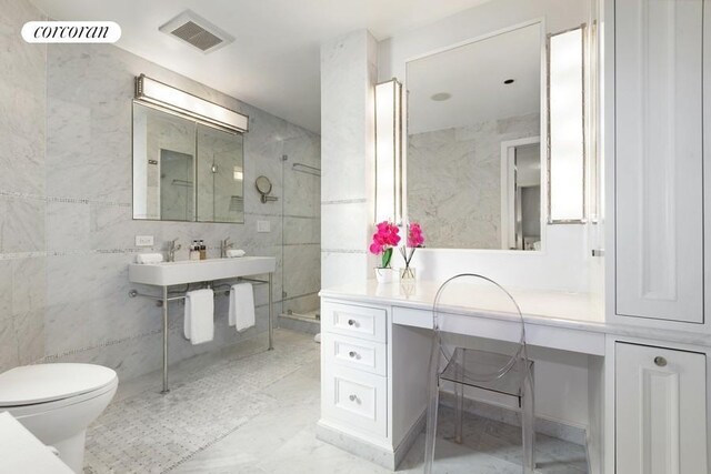 full bathroom with tile walls, a sink, a walk in shower, toilet, and visible vents