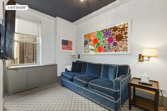 living area with baseboards and carpet
