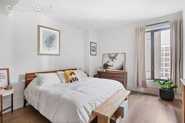 bedroom with multiple windows and wood finished floors