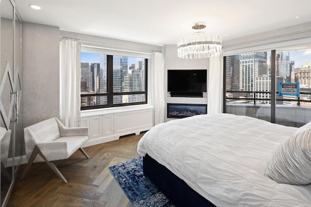 bedroom with parquet flooring, access to exterior, and an inviting chandelier