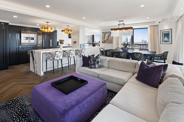 living room with an inviting chandelier, a wealth of natural light, and recessed lighting