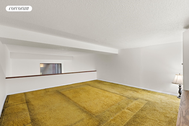 spare room with a textured ceiling, carpet floors, visible vents, and baseboards