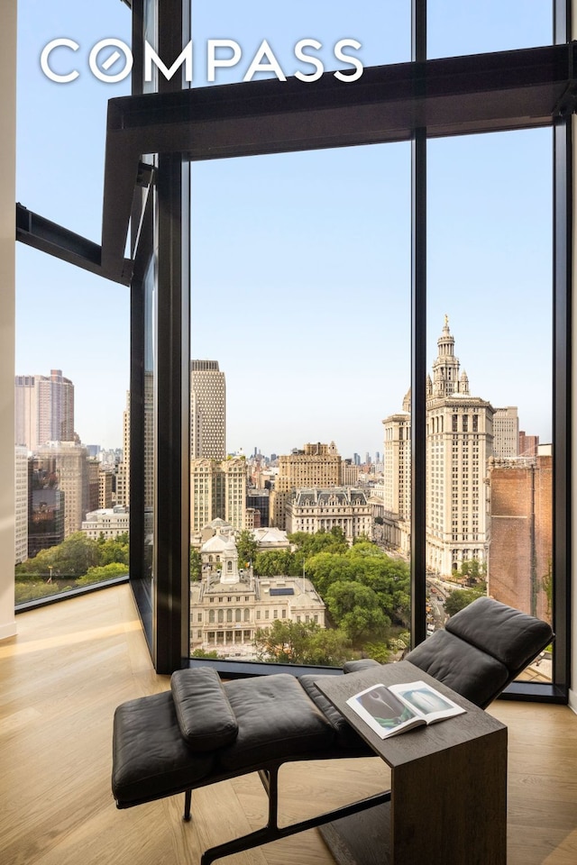 entryway with light wood finished floors, a view of city, and a wall of windows