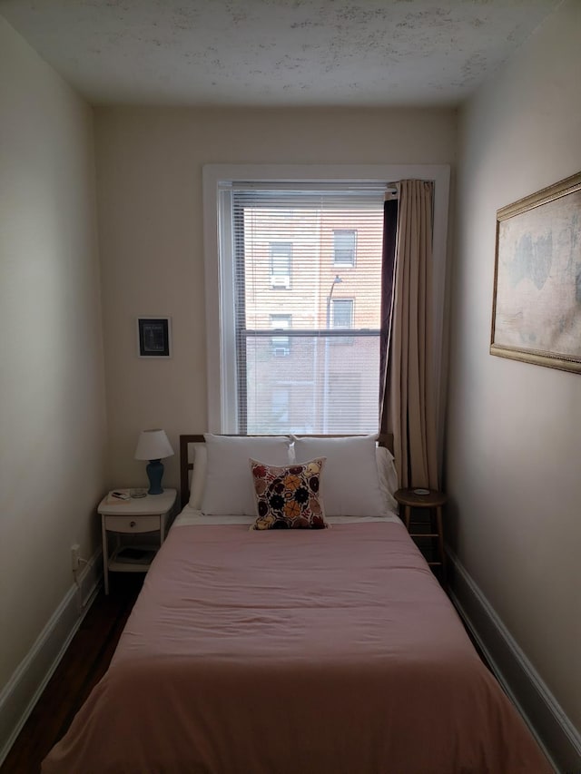 bedroom featuring dark wood-style flooring and baseboards