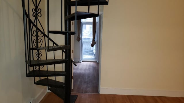 stairway with baseboards and wood finished floors