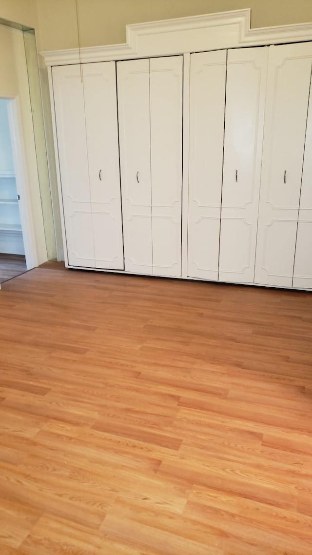 unfurnished bedroom featuring a closet and light wood-style flooring