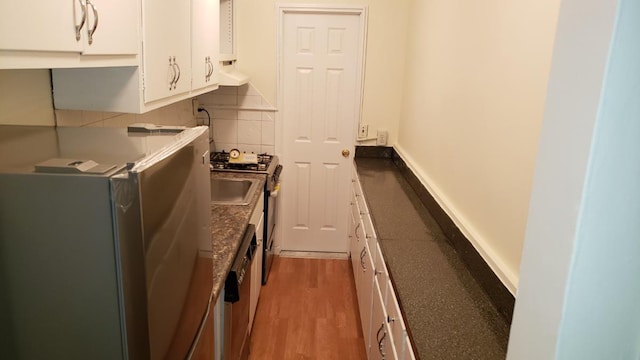 kitchen featuring white cabinets, light wood-style flooring, and backsplash