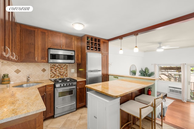 kitchen featuring backsplash, brown cabinets, appliances with stainless steel finishes, a kitchen breakfast bar, and a sink