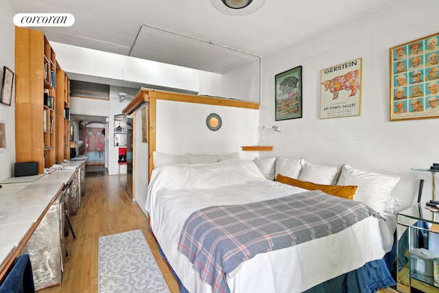 bedroom with light wood-type flooring, visible vents, and a closet