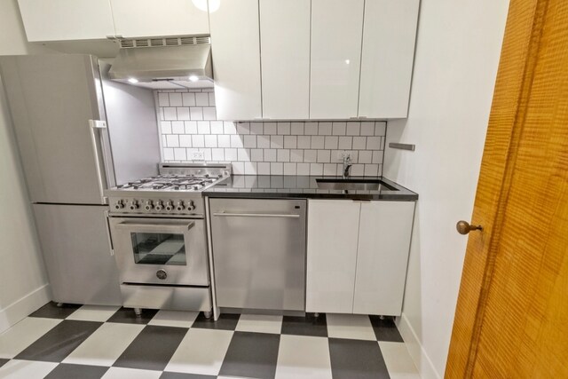 kitchen featuring exhaust hood, white cabinetry, stainless steel appliances, backsplash, and sink