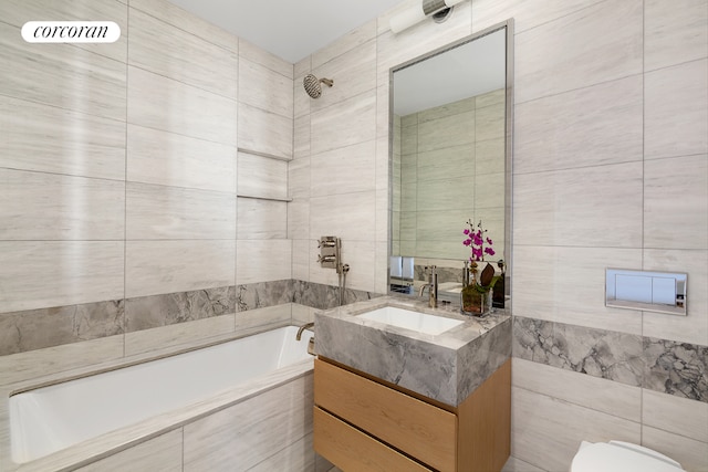 bathroom featuring tiled shower / bath, tile walls, and vanity