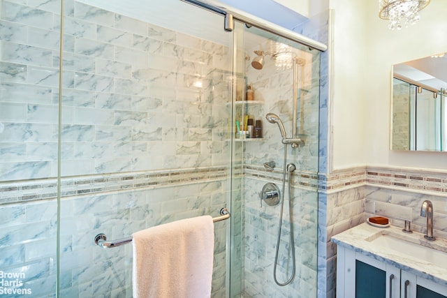 full bathroom featuring tile walls, a shower stall, and vanity