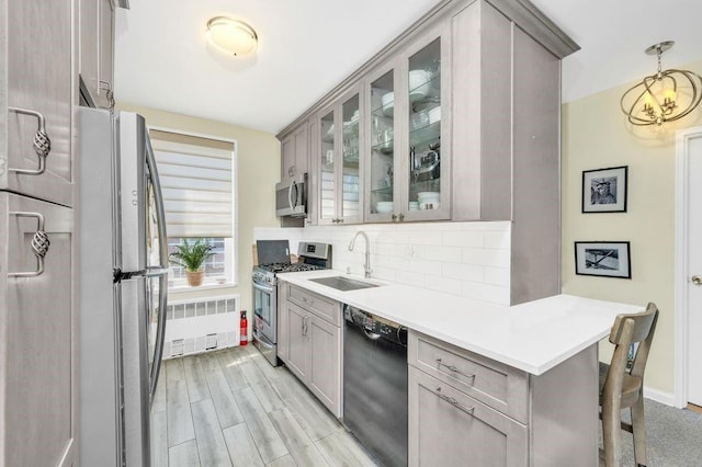 9201 Shore Rd Unit C702/703, New York City, NY 11209 - kitchen featuring appliances with stainless steel finishes, radiator, a sink, and gray cabinetry