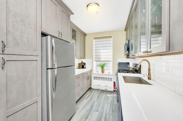 9201 Shore Rd Unit C702/703, New York City, NY 11209 - kitchen with stainless steel appliances, radiator heating unit, a sink, tasteful backsplash, and light countertops