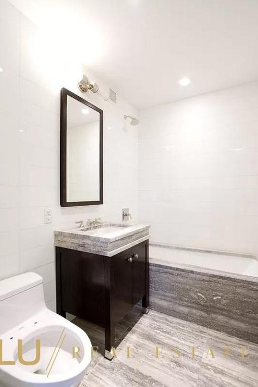 bathroom featuring toilet, vanity, tile walls, and hardwood / wood-style floors