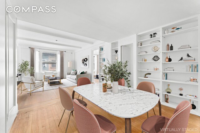 dining area with light wood-type flooring and built in shelves